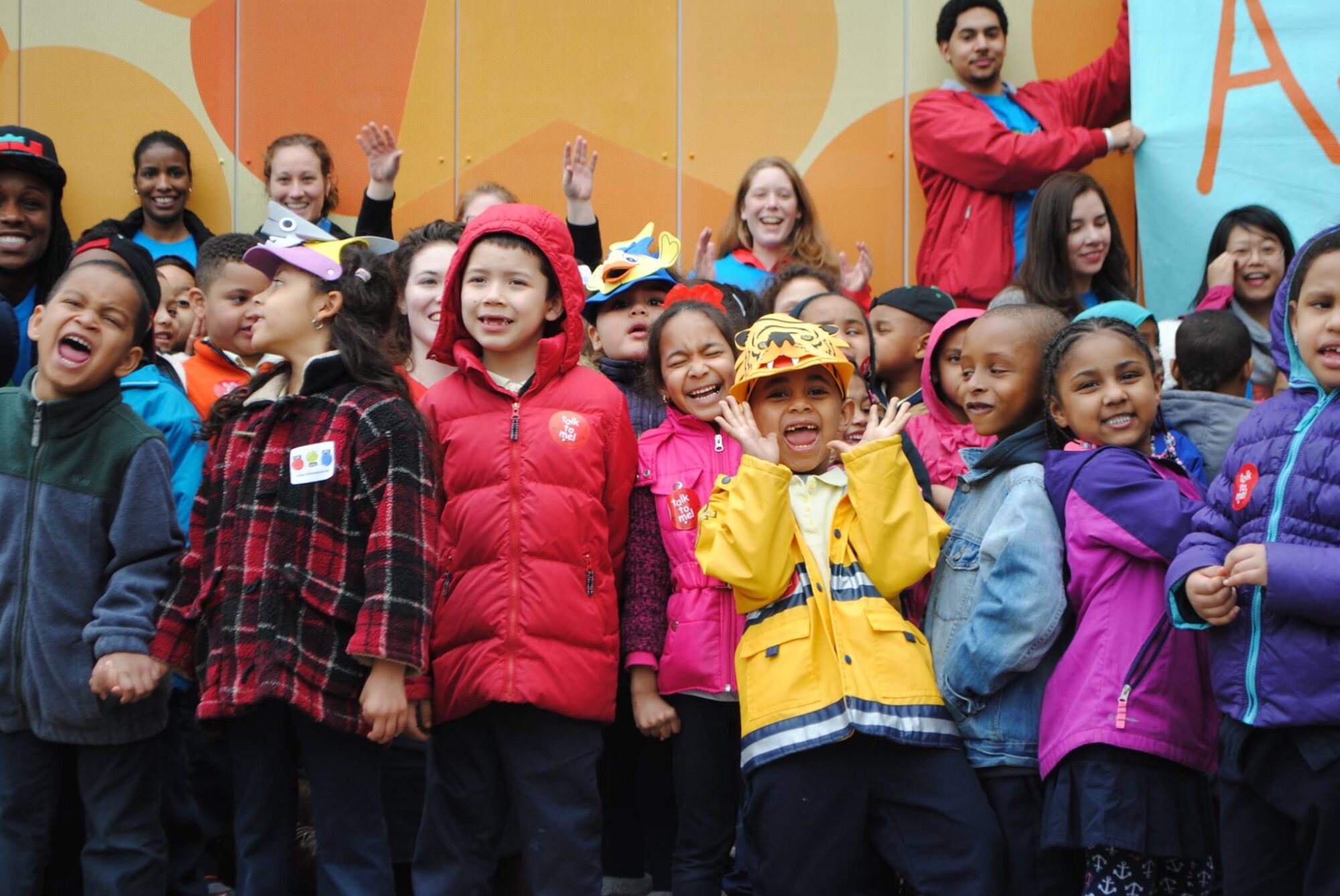 Banner showcasing a grantee, Countdown to Kindergarten. A group of happy children wait outside their school for a bus.